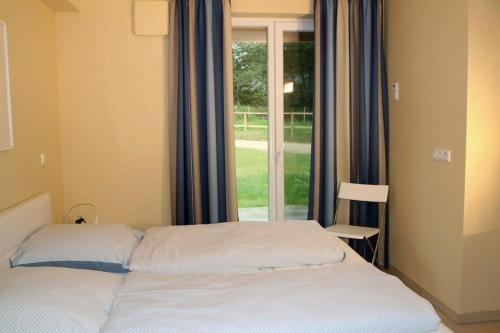 Schlafzimmer mit einem Bett vor einem Fenster in der Unterkunft Shattal in Friedenstal