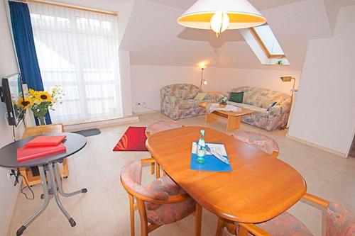 ein Wohnzimmer mit einem Tisch und einem Sofa in der Unterkunft Residenz "Am Postplatz", Whg 15 in Zingst