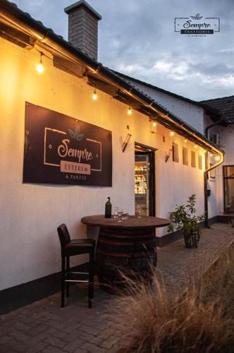a restaurant with a table and a sign on the side of it at Sempre Étterem És Panzió in Székesfehérvár