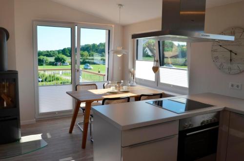 a kitchen with a counter and a table with a view at Ærø in Kronsgaard