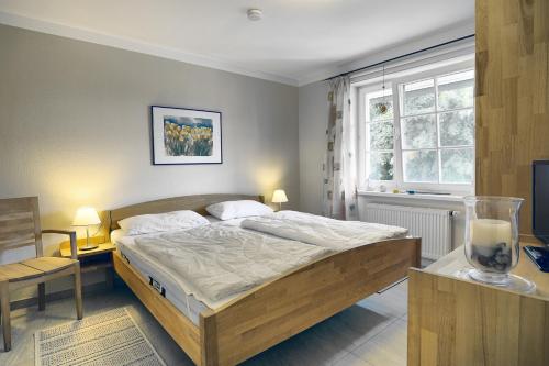 1 dormitorio con cama, escritorio y ventana en Mücke, Christian, en Zingst