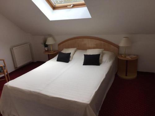 a bedroom with a large white bed with pillows at Ferienhaus Lutzmannsburg 2 mit direktem Thermenzugang und eigenem Garten in Lutzmannsburg