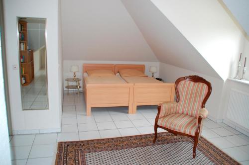 a bedroom with a bed and a chair at Privatzimmer Ehrhardt Nr2 in Burg auf Fehmarn