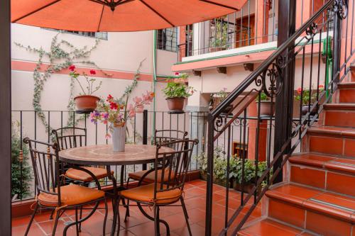 a patio area with a table and chairs with umbrellas at Rincón Familiar Hostel Boutique in Quito