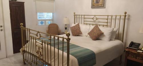 a bedroom with a large bed with white pillows at Posada de Maria Hotel Boutique & Spa in Durango