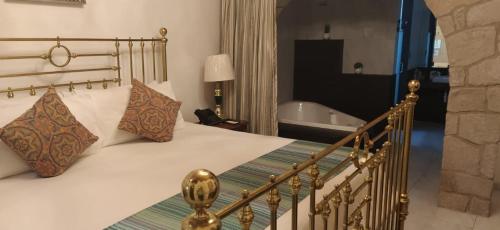 a bedroom with a bed and a bath tub at Posada de Maria Hotel Boutique & Spa in Durango
