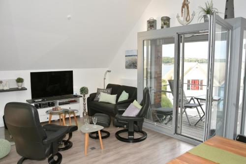 a living room with chairs and a flat screen tv at Ostsee - Appartement Nr 22 "Ankerplatz" im Strand Resort in Heiligenhafen