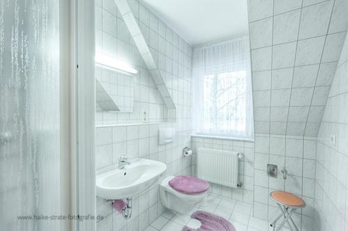 ein weißes Bad mit einem Waschbecken und einem WC in der Unterkunft Wolf, Barbara, FW 3 in Zingst