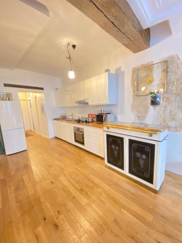 a large kitchen with white cabinets and a wooden floor at Beautiful appartment in the heart of Paris in Paris
