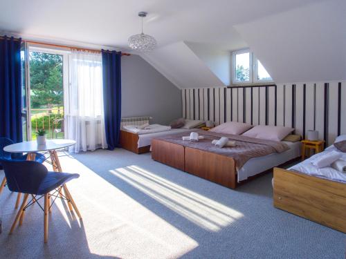 a large bedroom with two beds and a table at Leśne Zacisze in Weremień