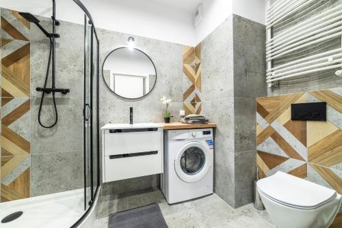 y baño con lavadora y ducha. en Apartamenty Przy IV Śluzie - Gold, en Bydgoszcz