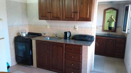 a kitchen with a sink and a stove and cabinets at Abuelo Coqui in Ramallo