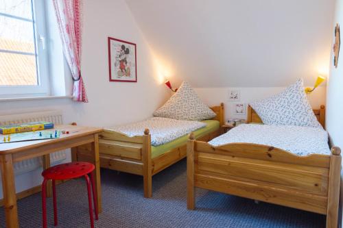 1 dormitorio con 2 camas, escritorio y mesa en Ferienhof Böhnke Nr3, en Puttgarden