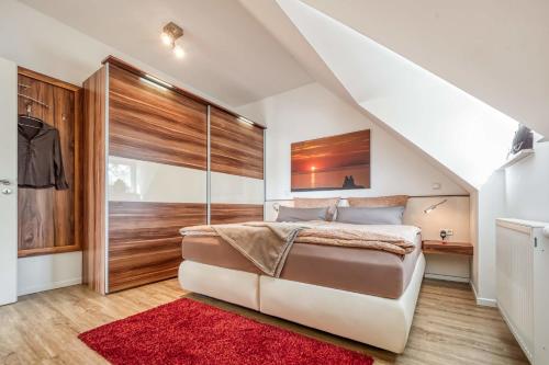 a bedroom with a large bed and a red rug at Les Belles, Haus Cecile, FW Romantique, Whg 5 in Zingst