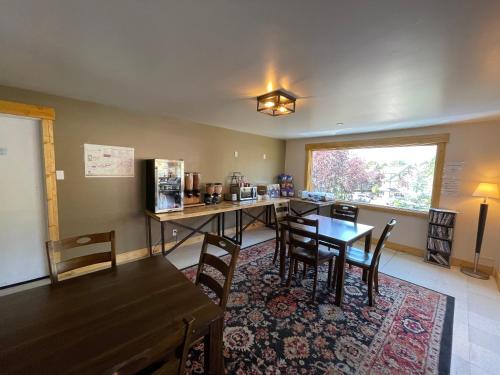 a room with a table and chairs and a kitchen at Estes Mountain Inn in Estes Park