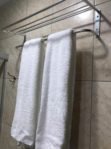 two white towels hanging on a towel rack in a bathroom at Atlântico Flat 209 in Natal