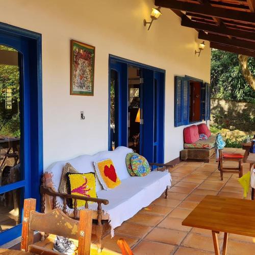 a living room with a white couch on a patio at Elephant GuestHouse Beira Mar - Suítes com Café da Manhã in Ilhabela