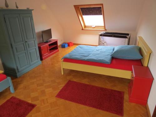 a small bedroom with a bed and a television at Ferienwohnung am Gässle in Altdorf