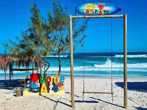 un columpio en la arena en una playa en Pousada da Lagoa, en Arraial do Cabo