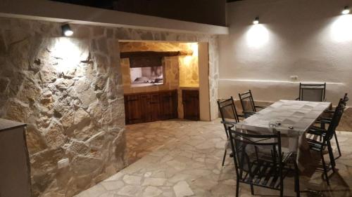 een eetkamer met een tafel en een stenen muur bij Deluxe Apartment Nika in Kaštela