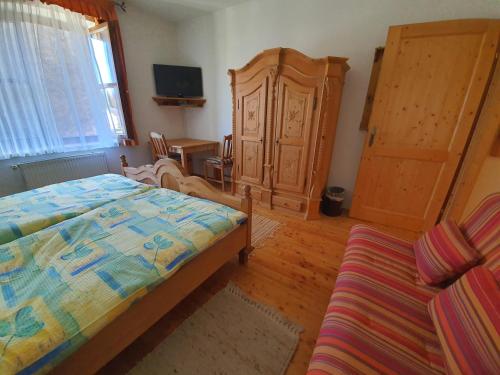 a bedroom with a bed and a cabinet and a couch at Gasthof Zum Wallner in Kalch