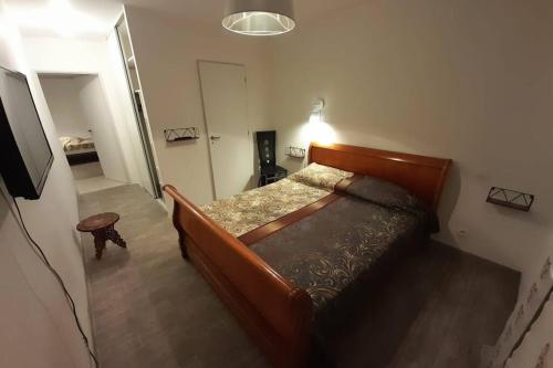 une chambre avec un lit en bois dans une pièce dans l'établissement Gîte classé 4 étoiles - 6 P. avec piscine chauffée, à Listrac-Médoc