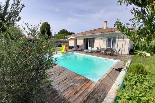 une piscine devant une maison dans l'établissement Gîte classé 4 étoiles - 6 P. avec piscine chauffée, à Listrac-Médoc