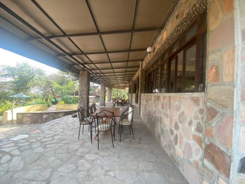 a patio with a table and chairs on a building at Oldarpoi Wageni Camps in Keekorok