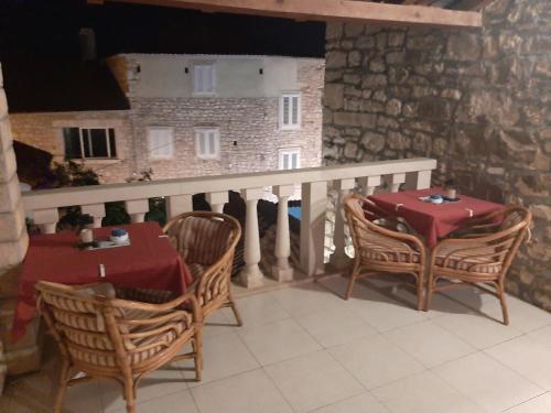 a balcony with a table and chairs and a building at Vila Dora Supetar in Supetar