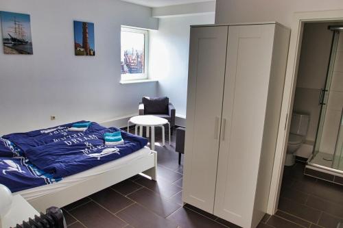 a bedroom with a bed and a cabinet and a chair at Segellast 2 in Lübeck