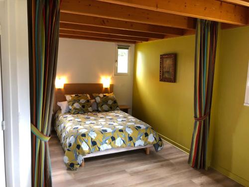 a bedroom with a bed in a room with yellow walls at Cottage Anadwen au pied du lac au duc et son golf in Ploërmel