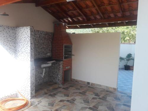 um quarto com uma lareira e uma parede de tijolos em Chalé Isabela em Ubatuba