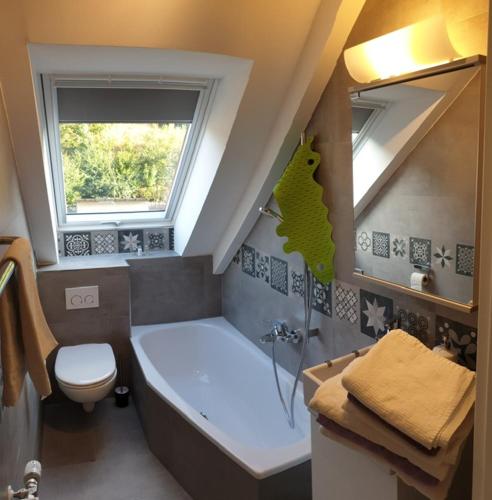 a bathroom with a tub and a toilet and a sink at Dachterrassenwohnung - nah am See in Biersdorf am See