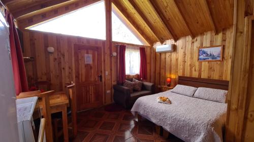a bedroom with a bed in a wooden cabin at Cabañas Kompatzki in Ancud