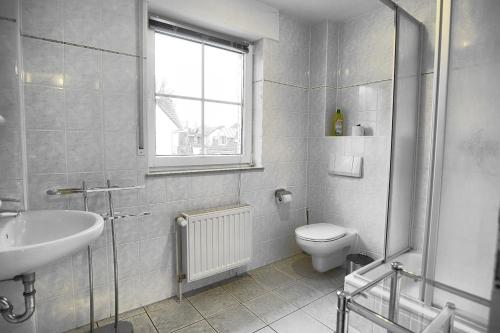 a bathroom with a sink and a toilet and a window at Am Strand 4,PP innen in Zingst