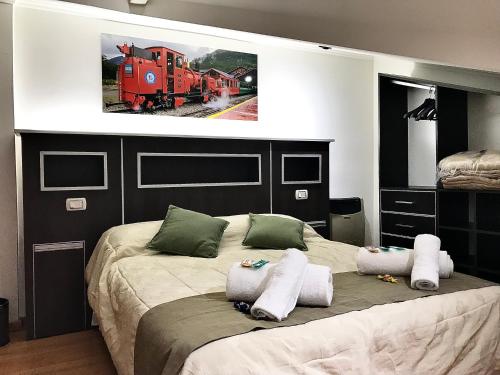 ein Schlafzimmer mit einem großen Bett mit einem Bahnbild an der Wand in der Unterkunft Cálido Destino in Ushuaia