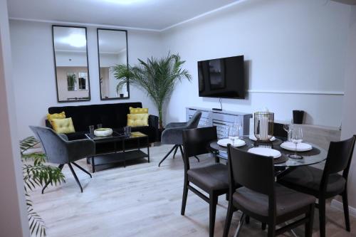 a dining room and living room with a table and chairs at Apartament Royal in Dej