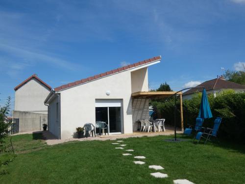 a white house with a patio and a lawn at gite de la libellule in Commentry