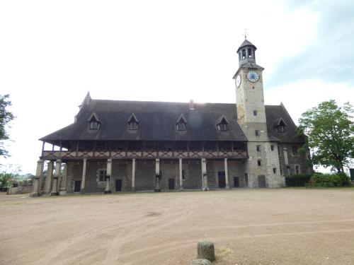 a large building with a clock tower on it at gite de la libellule in Commentry