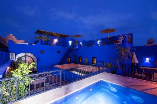 a villa with a swimming pool at night at Riad ViewPoint in Marrakesh