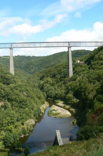 a bridge over a river in a forest with a river at gite de la libellule in Commentry