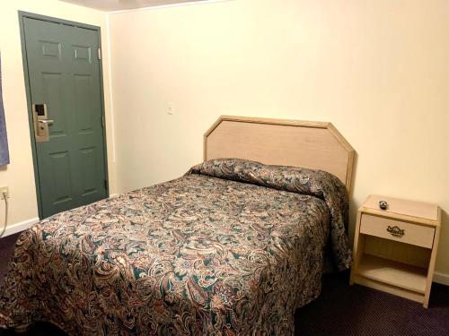 South Windsor的住宿－Nitey Nite Motel，一间卧室设有一张床和一个绿门