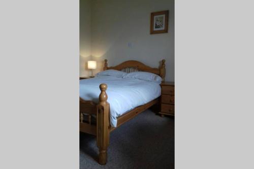 a bedroom with a bed with a wooden frame at Drumgowan House in Donegal
