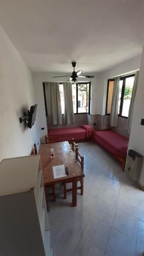 ein Wohnzimmer mit einem Tisch und einem roten Sofa in der Unterkunft Apart Hotel Complejo Estrella de Mar in San Bernardo