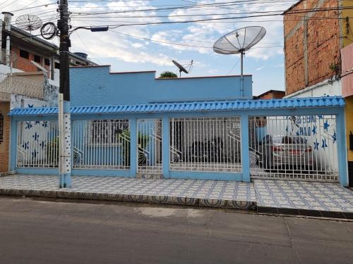 un edificio azul al lado de una calle en Suítes em Parintins, en Parintins