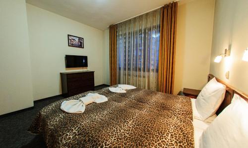 a hotel room with a bed with towels on it at Hotel Dumanov in Bansko