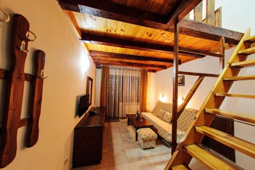 a living room with a couch and a staircase in a house at Hotel Dumanov in Bansko