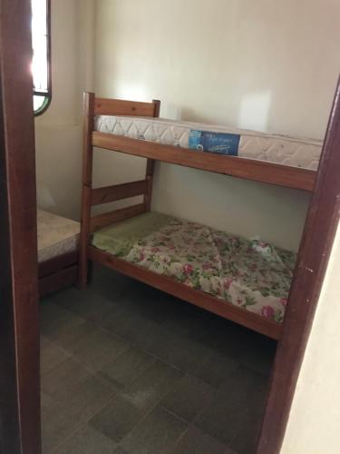 a bedroom with two bunk beds in a room at Casa Temporada Frente à Praia Piscina Ar cond Nova Viçosa VA in Nova Viçosa