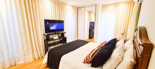 1 dormitorio con 1 cama y TV de pantalla plana en Studio Altos de Juramento en Salta