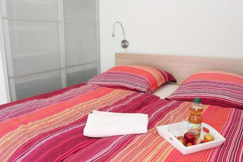 a bed with a bowl of fruit and a bottle of beer at L5 - Ferienanlage Lindenstraße 1 - FERIENDOMIZIL HOLLICH in Grömitz